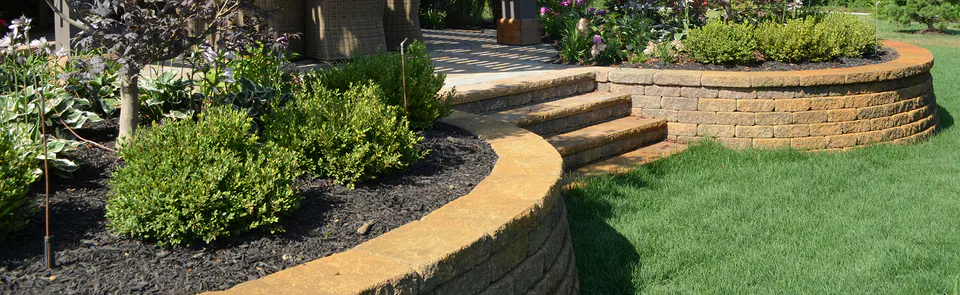 Two-tier segmental block retaining wall with a mulched planting bed and lawn